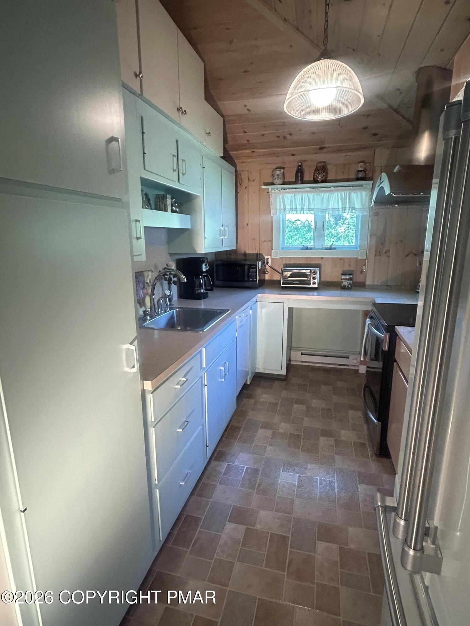 4379 River Road Mount Bethel, PA 18343 - Photo 27 of 48 a large kitchen with stainless steel appliances a large counter top a stove a chimney a sink and dishwasher