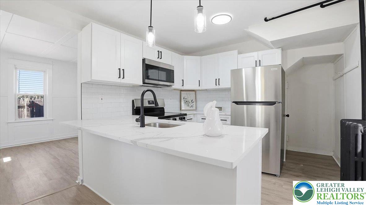 322 East Garrison Street Bethlehem, PA 18018 - Photo 4 of 24 a kitchen with kitchen island a white counter top space cabinets and stainless steel appliances