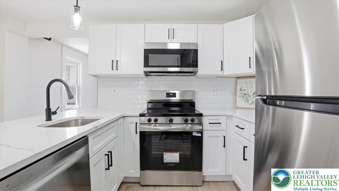 322 East Garrison Street Bethlehem, PA 18018 - Photo 6 of 24 a kitchen with stainless steel appliances a stove a sink a refrigerator a microwave and cabinets