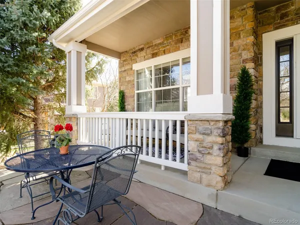 a porch area with table and chairs