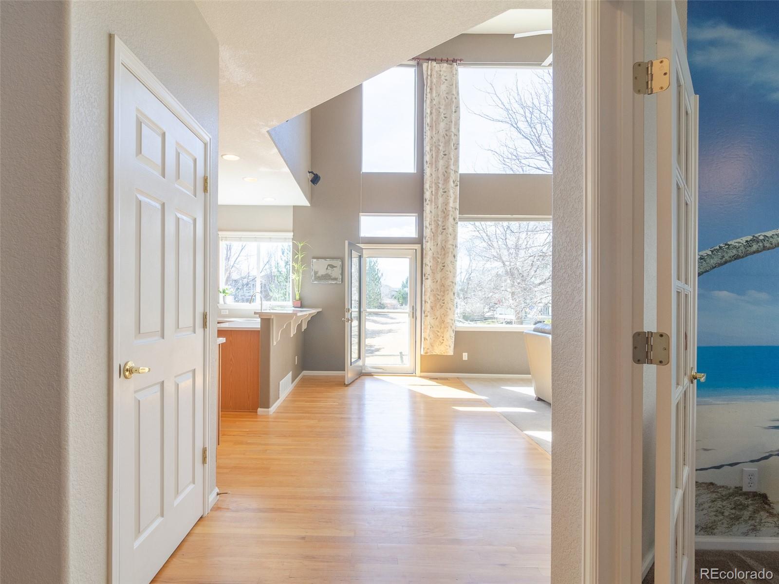 2080 Pearl Howlett Road Longmont, CO 80504 - Photo 15 of 46 a view of an entryway with wooden floor and a living room