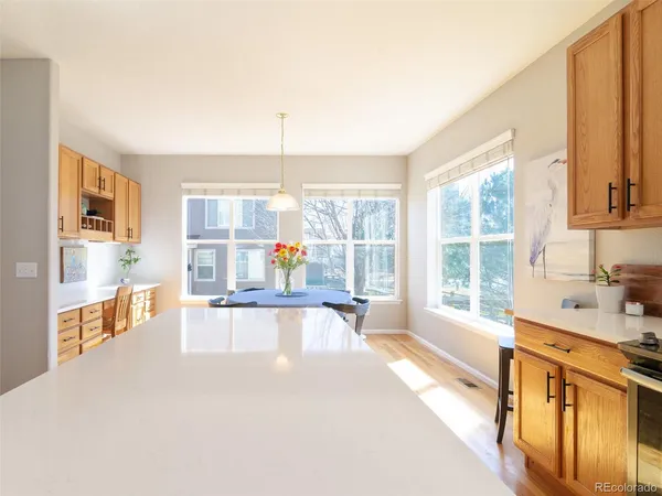 a view of a kitchen with kitchen island a large window cabinets a sink and stainless steel appliances