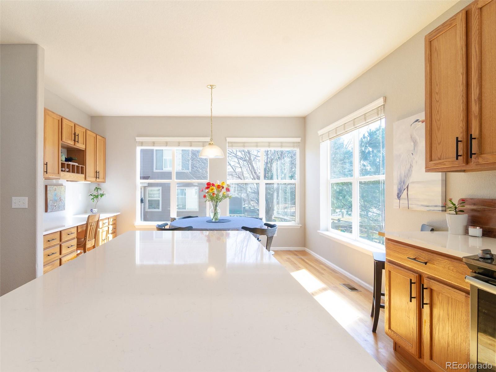 2080 Pearl Howlett Road Longmont, CO 80504 - Photo 21 of 46 a view of a kitchen with kitchen island a large window cabinets a sink and stainless steel appliances