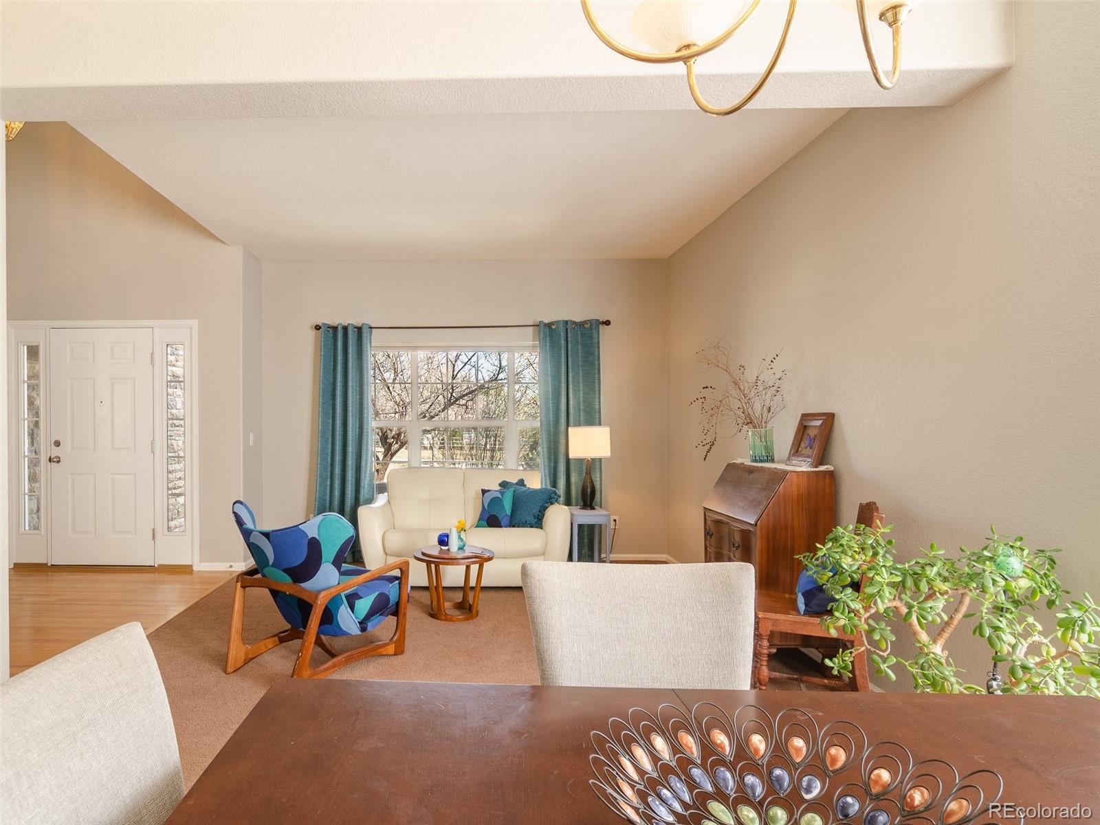 2080 Pearl Howlett Road Longmont, CO 80504 - Photo 26 of 46 a living room with furniture a window and a potted plant