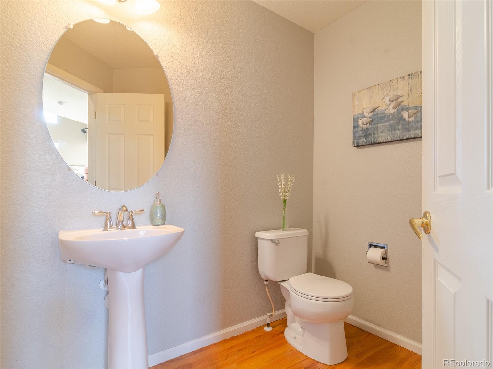 2080 Pearl Howlett Road Longmont, CO 80504 - Photo 29 of 46 a bathroom with a toilet sink and mirror