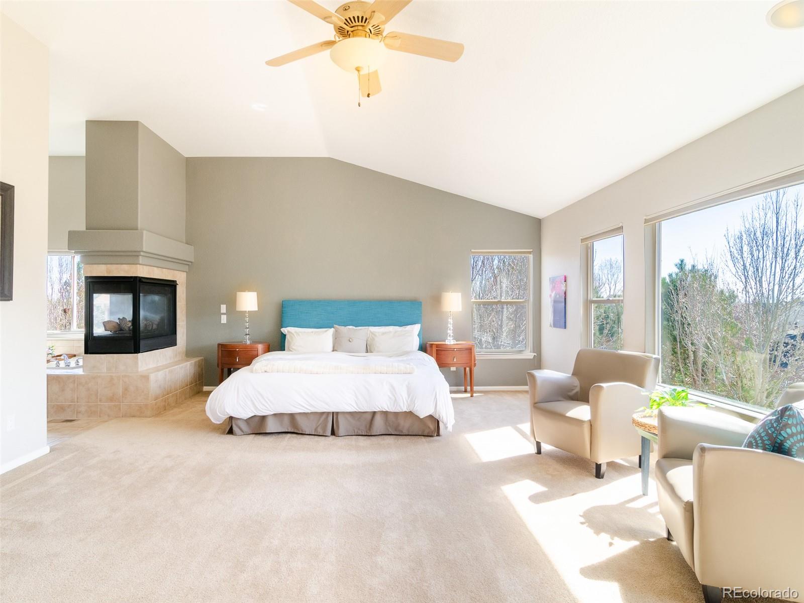 2080 Pearl Howlett Road Longmont, CO 80504 - Photo 31 of 46 a bedroom with a large bed and a fireplace