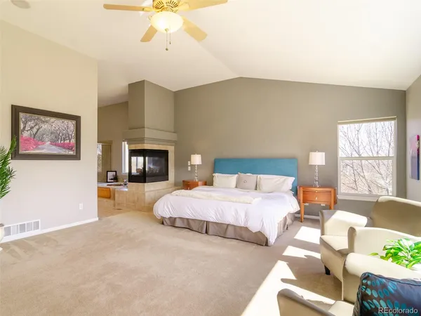 a spacious bedroom with a bed and a fireplace