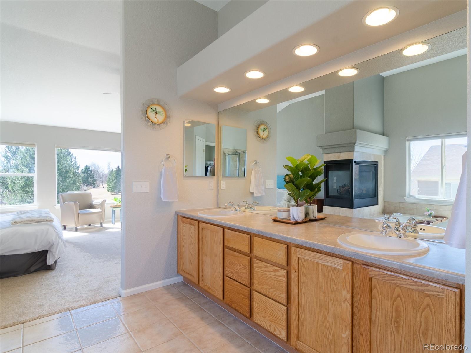 2080 Pearl Howlett Road Longmont, CO 80504 - Photo 38 of 46 a bathroom with a double vanity sink and a mirror