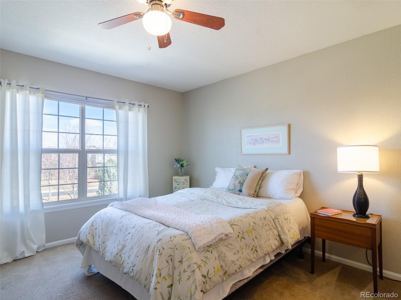 2080 Pearl Howlett Road Longmont, CO 80504 - Photo 44 of 46 a bedroom with a large bed and a chandelier