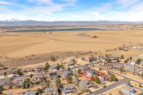 an aerial view of ocean and residential houses with outdoor space