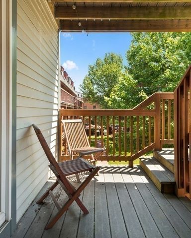 a view of a balcony with chairs and wooden floor