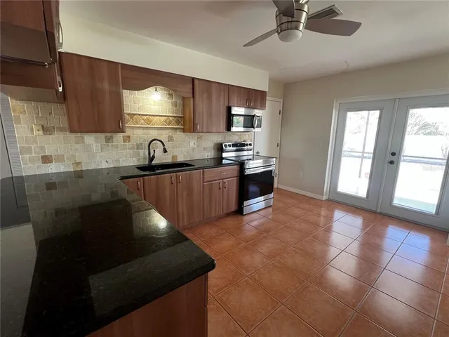 a kitchen with granite countertop a stove sink and cabinets