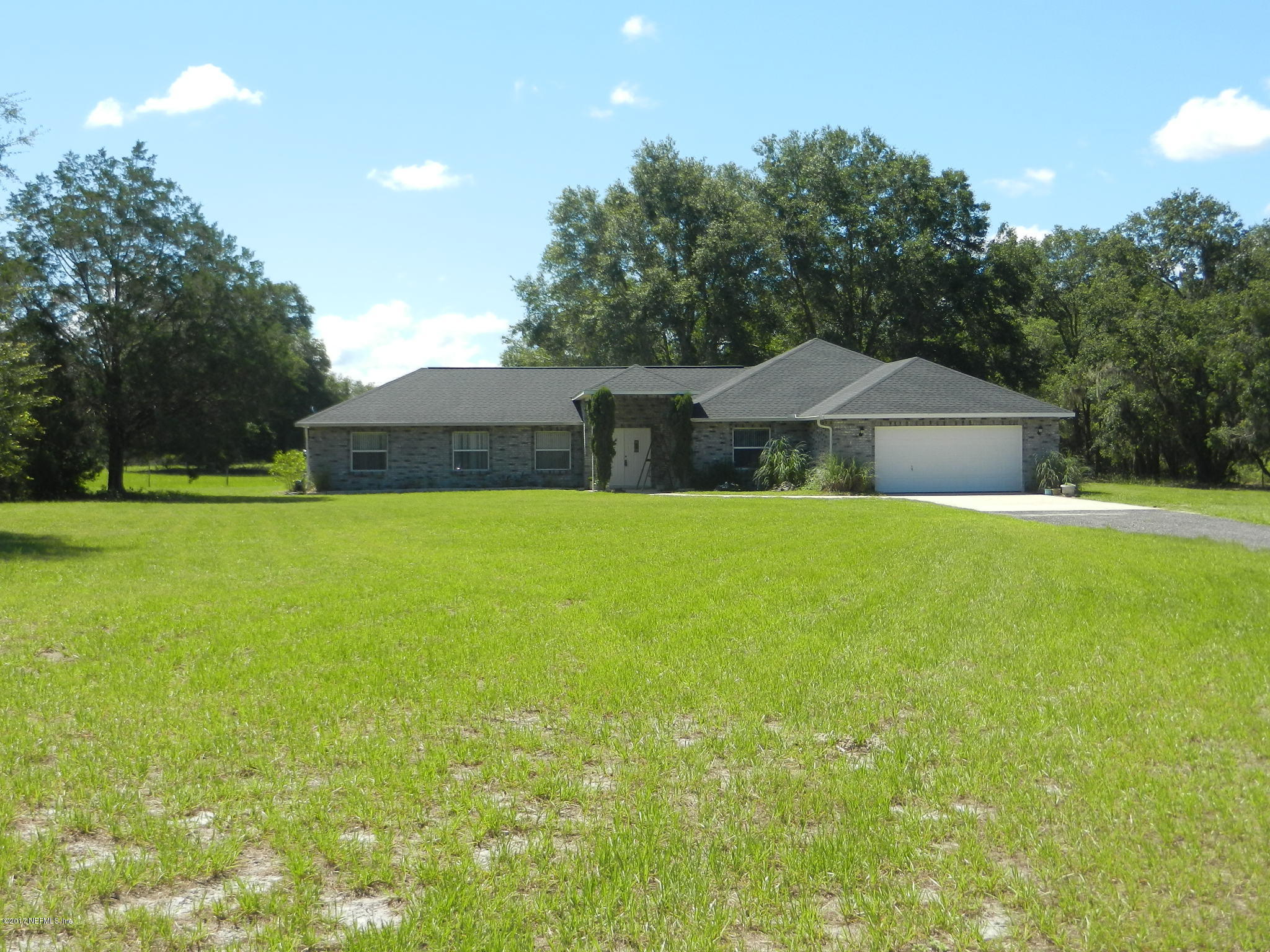 2205 Brownlee Road Seville, FL 32190 - Photo 27 of 27 a swimming pool is sitting in the grass with large trees