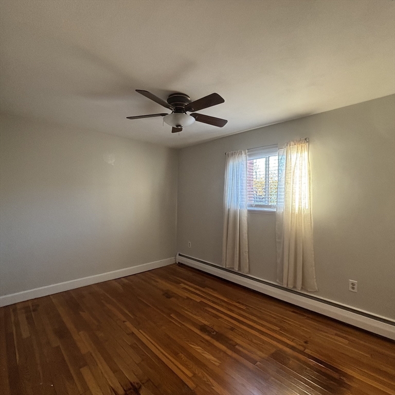 701 Adams Street, Unit 9 Boston, MA 02122 - Photo 12 of 19 an empty room with wooden floor and windows