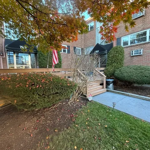a front view of a house with a yard and tree s