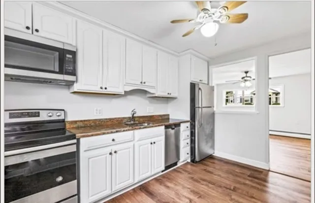 a kitchen with stainless steel appliances white cabinets and a refrigerator