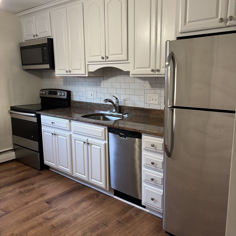 701 Adams Street, Unit 9 Boston, MA 02122 - Photo 5 of 19 a kitchen with cabinets appliances and wooden floor