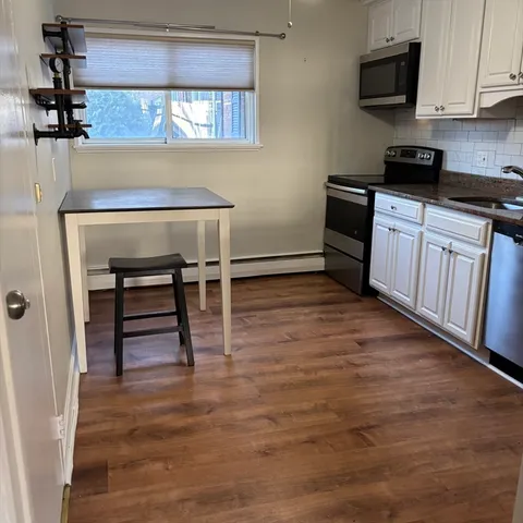 a kitchen with granite countertop a stove a sink and a microwave