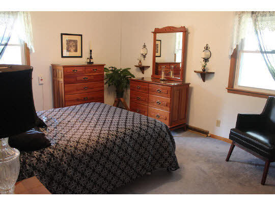 4807 Mohawk Road Rockford, IL 61107 - Photo 6 of 11 a bedroom with a bed and dresser with mirror