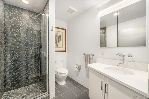 a bathroom with a sink toilet a mirror and shower