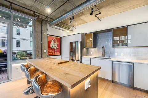 a kitchen with stainless steel appliances granite countertop a sink a stove and a refrigerator