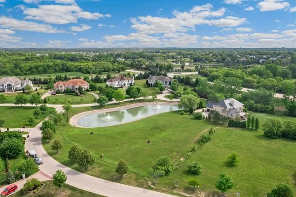 an aerial view of a house with a yard and lake view in back