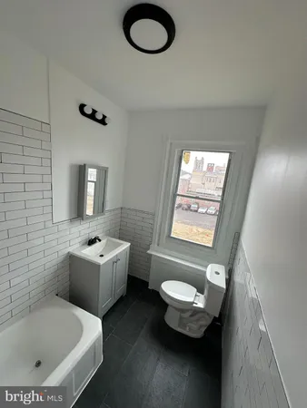 a bathroom with a tub sink and mirror
