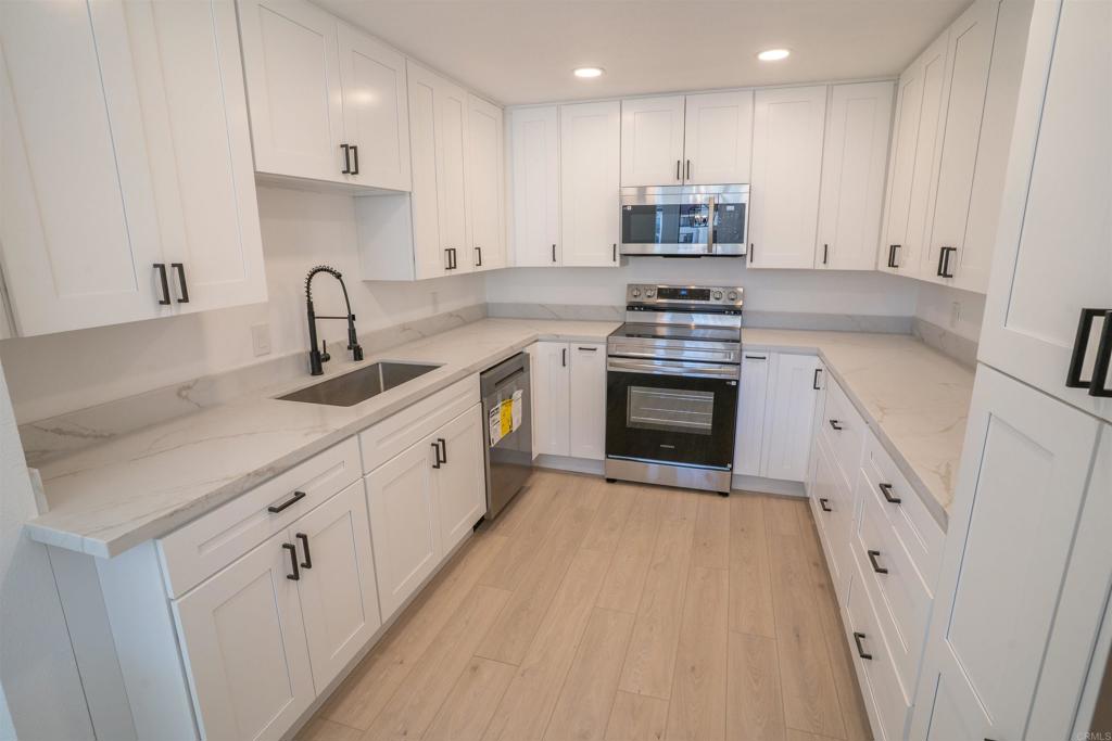 5845 Friars Road, Unit 1316 San Diego, CA 92110 - Photo 1 of 29 a kitchen with granite countertop white cabinets and white appliances