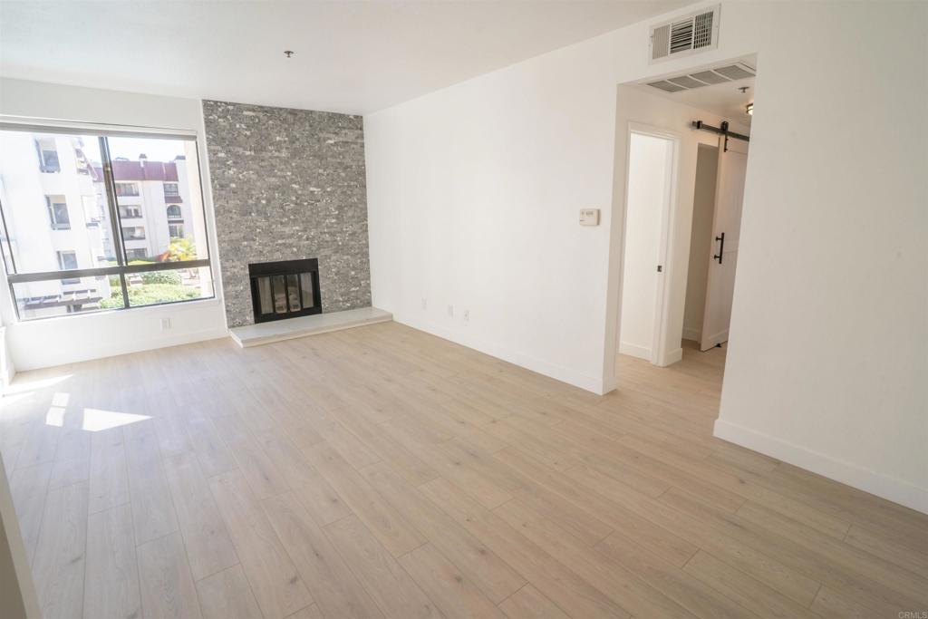 5845 Friars Road, Unit 1316 San Diego, CA 92110 - Photo 12 of 29 a view of an empty room with a fireplace and a window