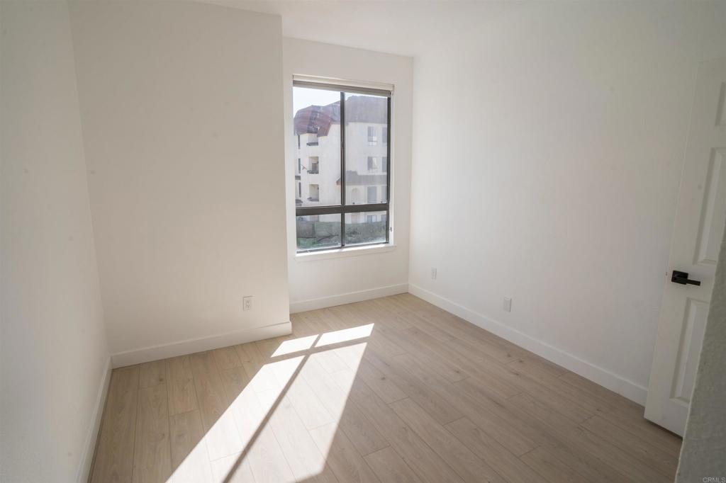 5845 Friars Road, Unit 1316 San Diego, CA 92110 - Photo 15 of 29 an empty room with wooden floor and windows