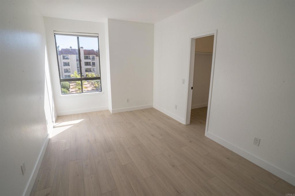 5845 Friars Road, Unit 1316 San Diego, CA 92110 - Photo 23 of 29 an empty room with wooden floor and windows