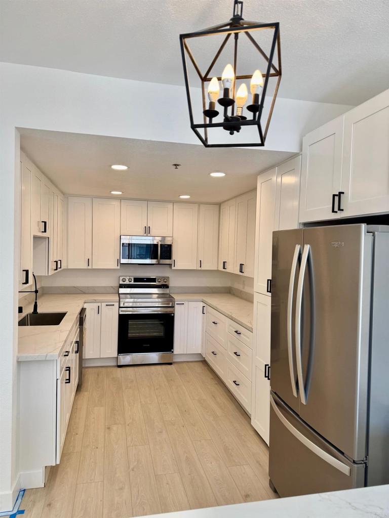 5845 Friars Road, Unit 1316 San Diego, CA 92110 - Photo 26 of 29 a kitchen with stainless steel appliances a refrigerator sink and cabinets
