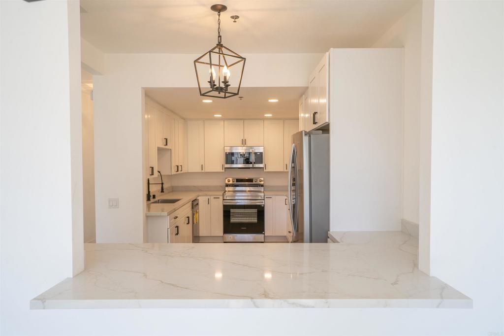 5845 Friars Road, Unit 1316 San Diego, CA 92110 - Photo 8 of 29 a view of a kitchen with a sink stainless steel appliances and cabinets
