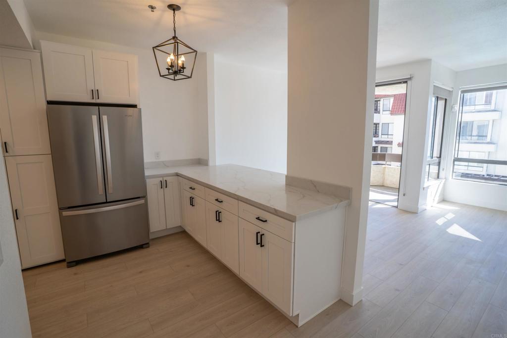 5845 Friars Road, Unit 1316 San Diego, CA 92110 - Photo 9 of 29 a kitchen with stainless steel appliances a refrigerator and a window