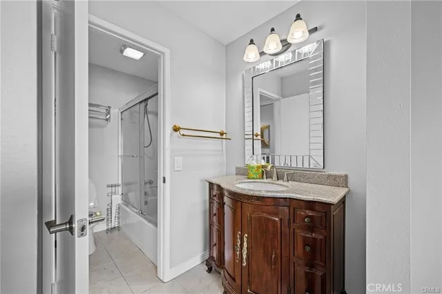 a bathroom with a granite countertop sink a mirror and a shower