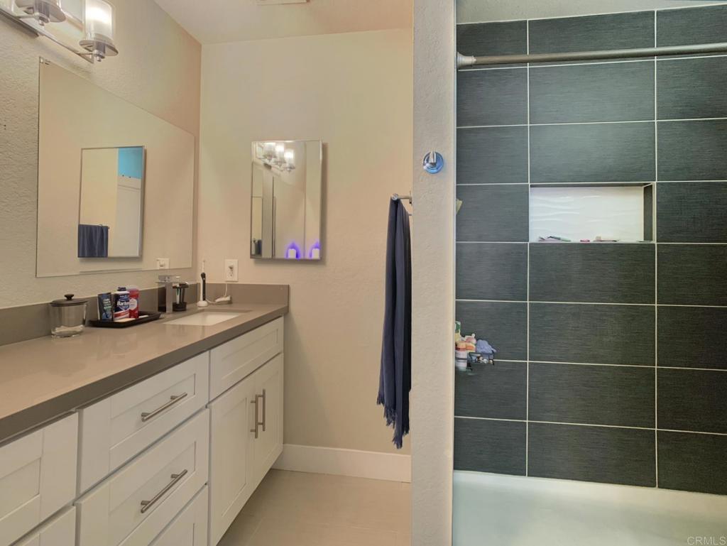 13758 Pomerado Road Poway, CA 92064 - Photo 22 of 32 a bathroom with a double vanity sink a mirror and a shower
