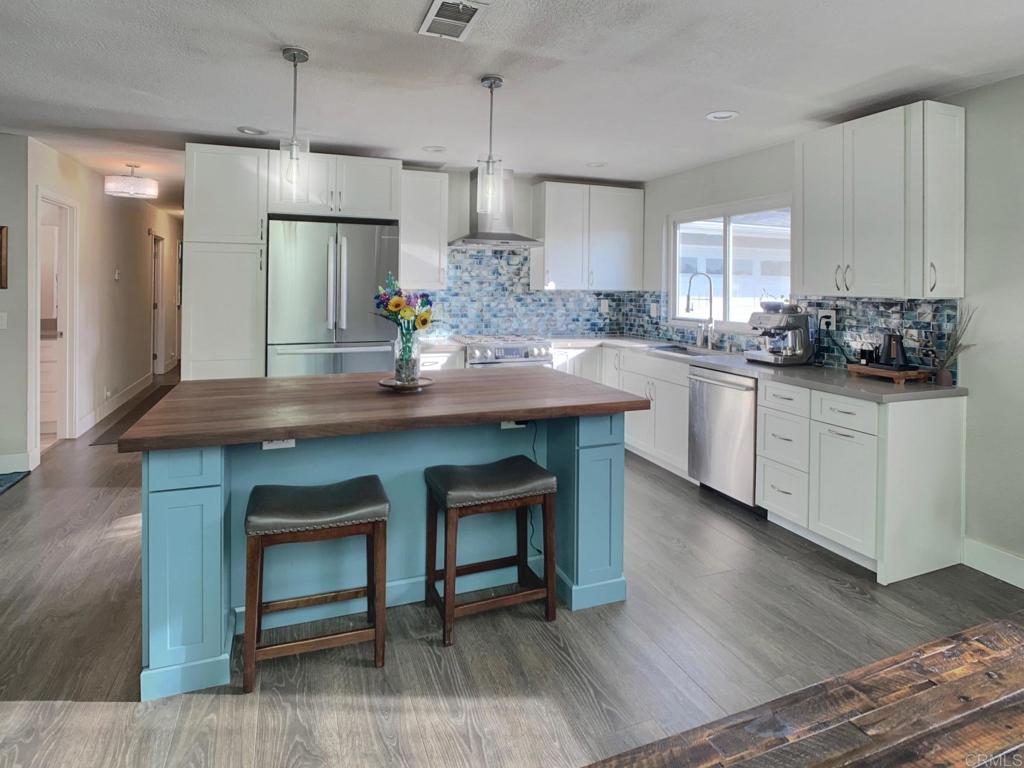 13758 Pomerado Road Poway, CA 92064 - Photo 6 of 32 a kitchen with granite countertop a sink cabinets and wooden floor
