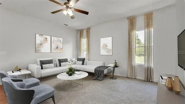 a living room with furniture a dining table and a chandelier