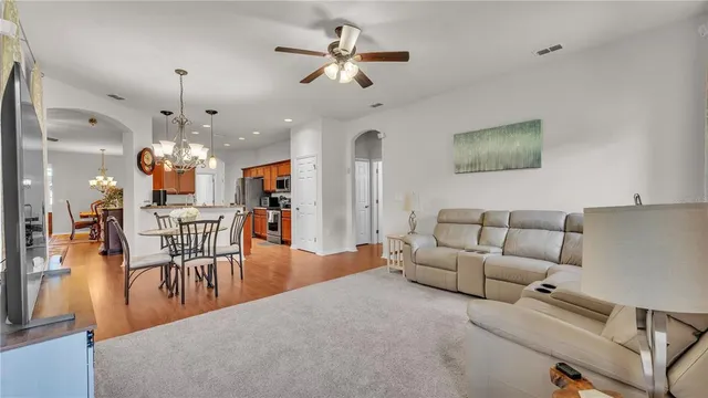 a kitchen with stainless steel appliances granite countertop a stove top oven a sink a dining table and chairs