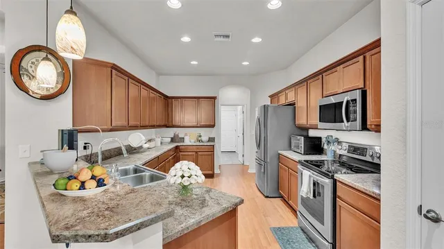 a kitchen with stainless steel appliances granite countertop a refrigerator stove microwave and sink