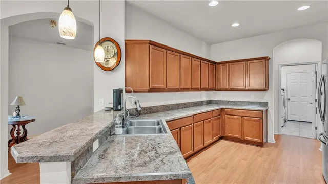 a kitchen with stainless steel appliances granite countertop a sink stove and cabinets