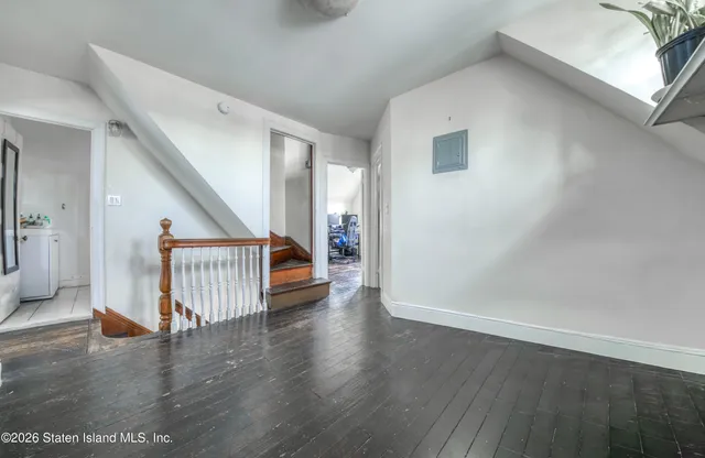 a view of a hallway with wooden floor and stairs