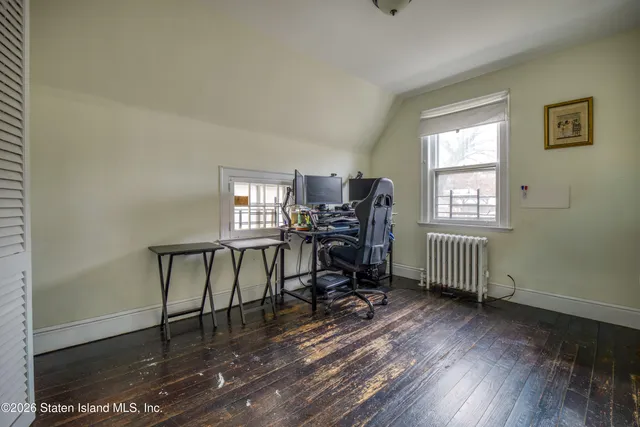 a view of a workspace with furniture and a window