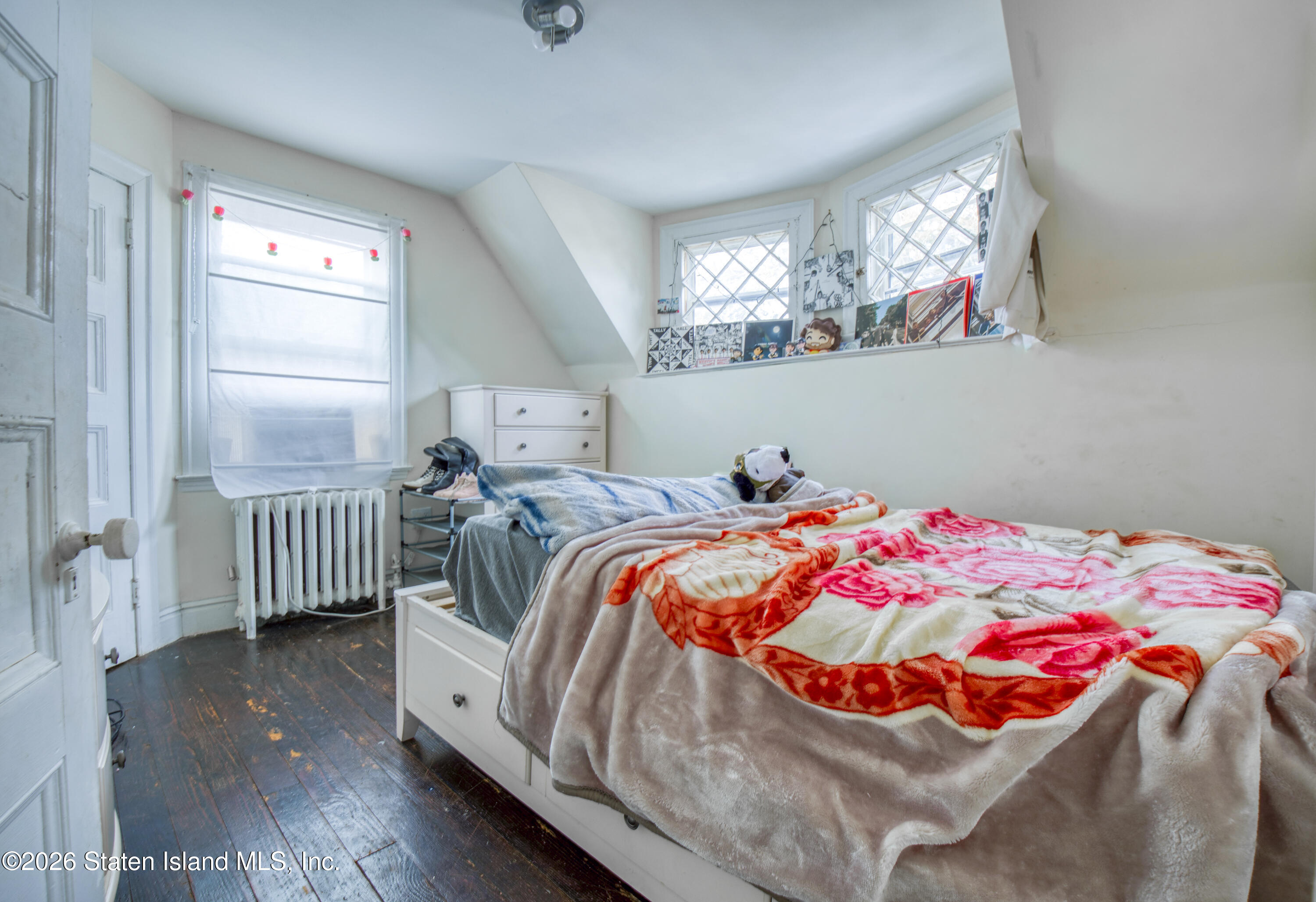 226 Castleton Avenue Staten Island, NY 10301 - Photo 19 of 32 a bedroom with a bed and a chandelier