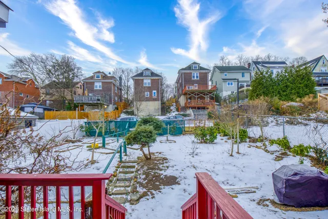 a view of a patio with couches and a table and chairs with wooden fence