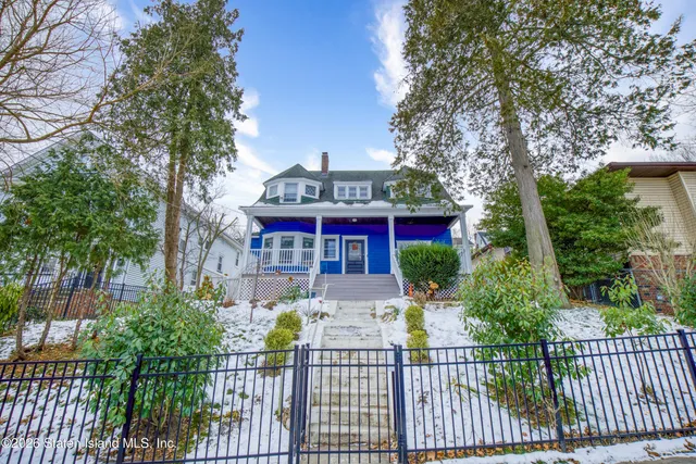a view of a house with brick walls and flower plants