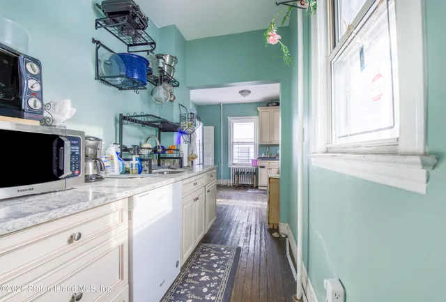 a kitchen with sink cabinets and flat screen tv