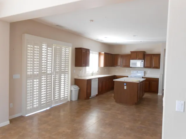 a large kitchen with kitchen island granite countertop a stove a sink dishwasher and a refrigerator