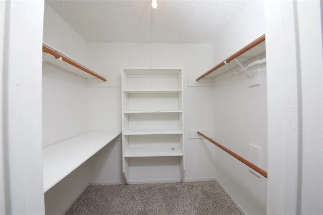 a view of walk in closet with empty racks