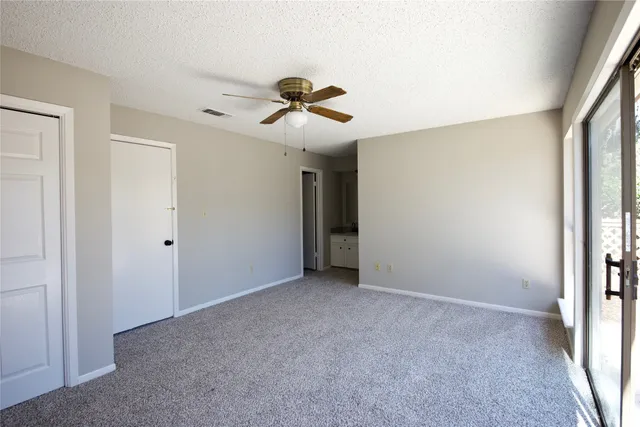 a view of a livingroom with a ceiling fan and window
